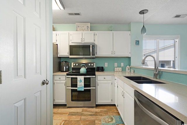 kitchen featuring white cabinetry, visible vents, appliances with stainless steel finishes, and a sink