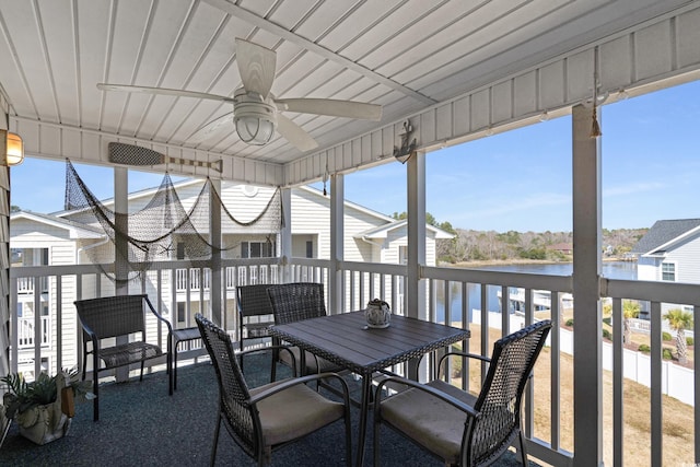 unfurnished sunroom with ceiling fan and a water view