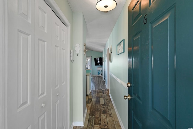 hallway with dark wood-style floors and baseboards