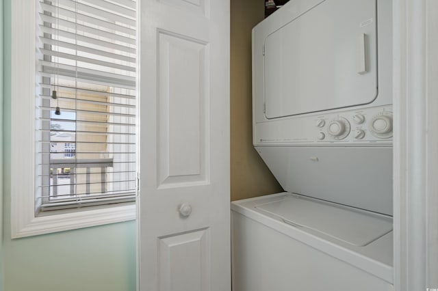 clothes washing area with laundry area and stacked washer and dryer