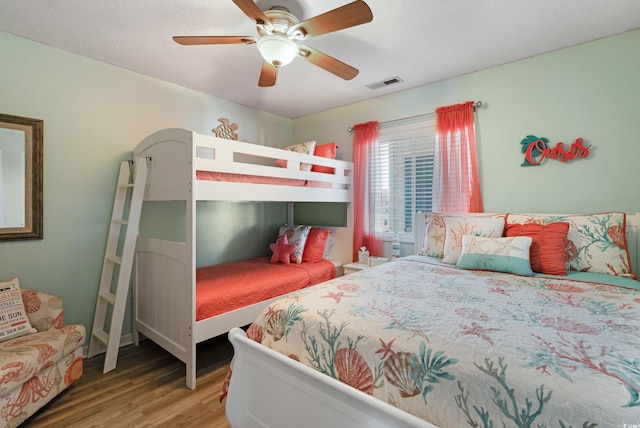 bedroom with visible vents, a ceiling fan, and wood finished floors