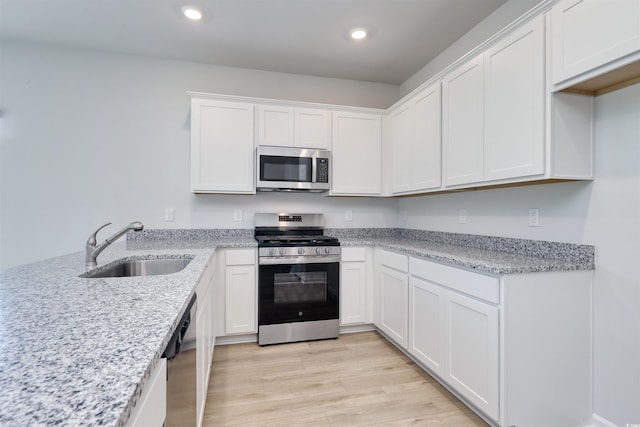 495 Wagner Cir, Conway, SC 29526 - kitchen with appliances with stainless steel finishes, white cabinets, recessed lighting, light wood-style floors, and light stone countertops