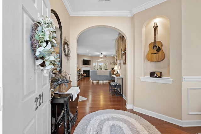 entryway with dark wood-type flooring, baseboards, arched walkways, and ceiling fan