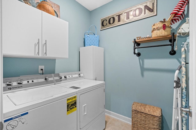 washroom featuring washer and dryer, baseboards, cabinet space, and light tile patterned floors