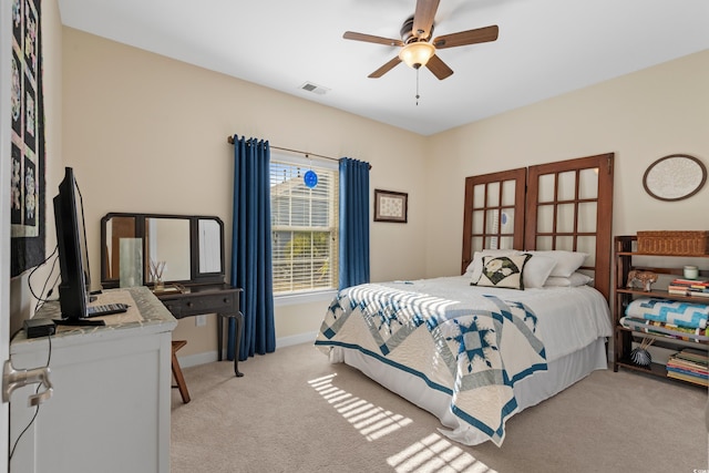 bedroom with visible vents, baseboards, light colored carpet, and a ceiling fan