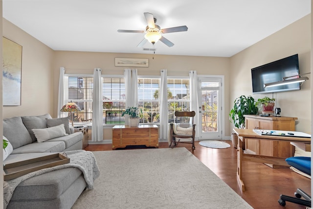 living area featuring baseboards, ceiling fan, and wood finished floors