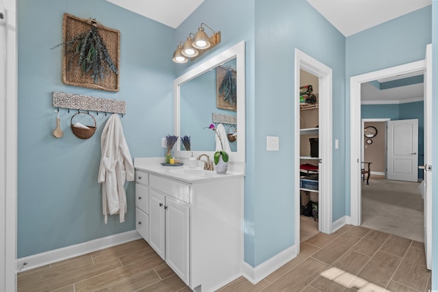 full bath featuring vanity, baseboards, and wood tiled floor