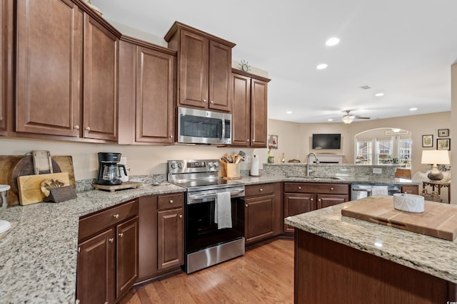 kitchen with a sink, recessed lighting, stainless steel appliances, light wood-style floors, and ceiling fan