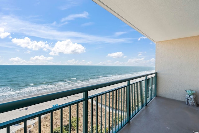 balcony featuring a view of the beach and a water view