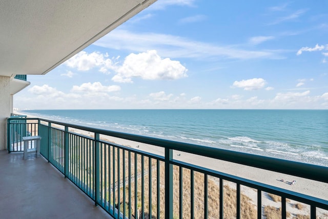 balcony featuring a water view and a beach view