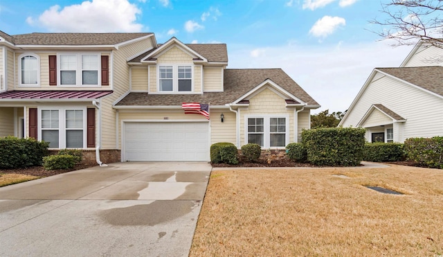 view of front facade with an attached garage, concrete driveway, a front yard, and a shingled roof