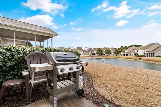 view of patio / terrace featuring area for grilling, a residential view, and a water view