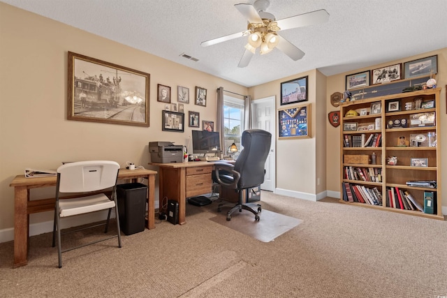 office space with baseboards, visible vents, ceiling fan, a textured ceiling, and carpet flooring