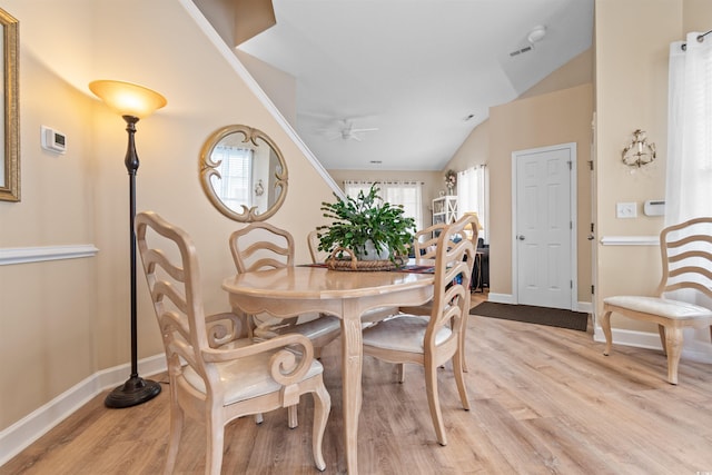 dining area featuring a wealth of natural light, light wood-style floors, a ceiling fan, and vaulted ceiling