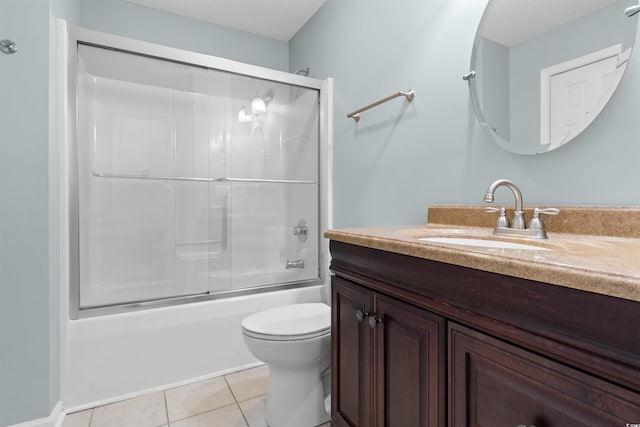 bathroom with tile patterned floors, combined bath / shower with glass door, toilet, and vanity