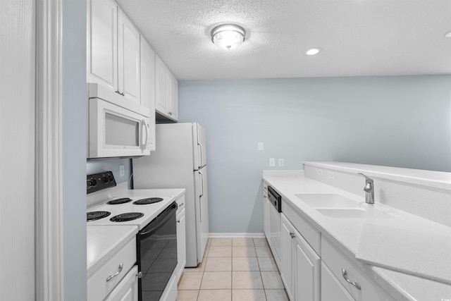 kitchen featuring light countertops, light tile patterned floors, white appliances, white cabinetry, and a sink