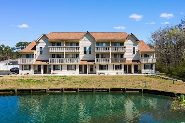 back of property featuring a water view and a balcony