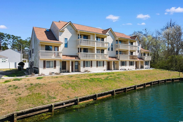 back of property featuring a water view and a balcony