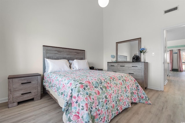 bedroom with baseboards, visible vents, and light wood-type flooring