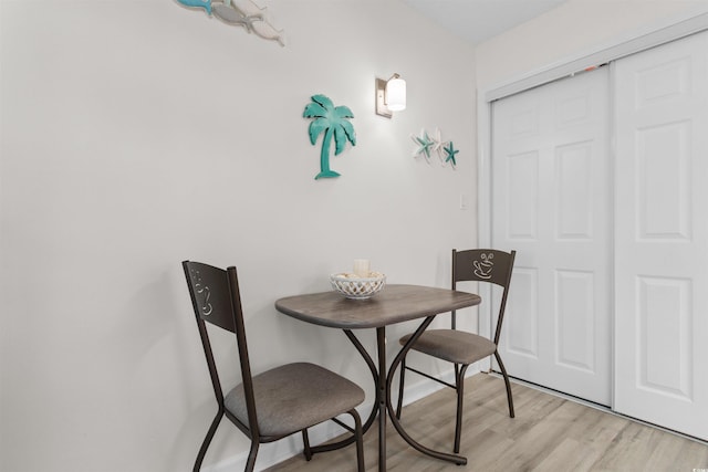 dining area with baseboards and light wood-type flooring