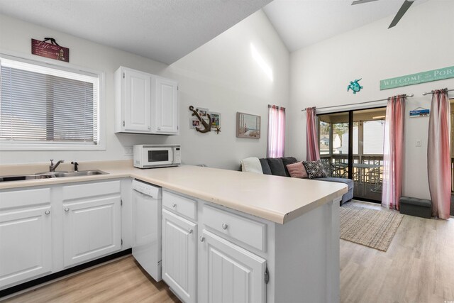 510 Fairwood Lakes Dr Unit 18-P, Myrtle Beach, SC 29588 - kitchen featuring a sink, a peninsula, light wood-style floors, white appliances, and white cabinetry
