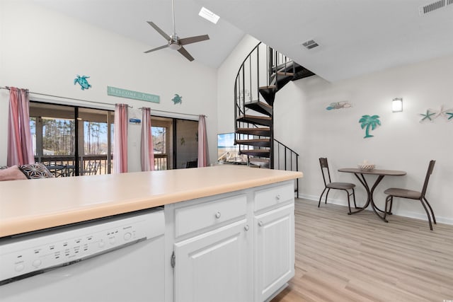 kitchen with white dishwasher, high vaulted ceiling, light wood finished floors, and visible vents