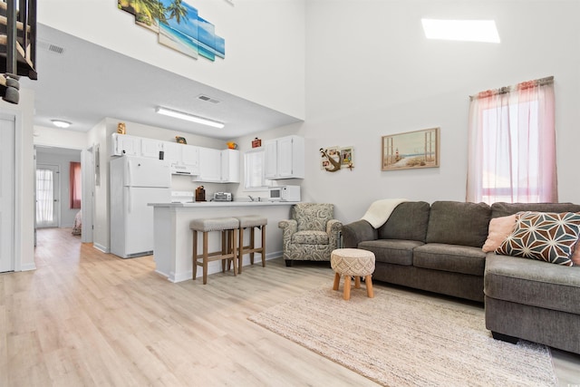 living room featuring visible vents and light wood-style floors