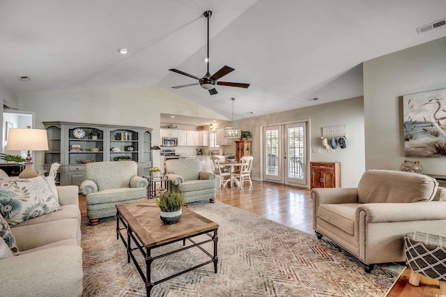 living room with visible vents, high vaulted ceiling, light wood-style flooring, a ceiling fan, and french doors