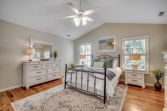 bedroom featuring vaulted ceiling, baseboards, visible vents, and light wood finished floors