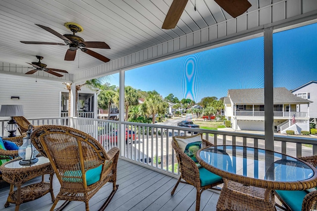 deck with a residential view, outdoor dining space, and a ceiling fan