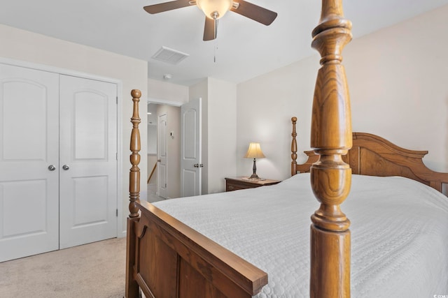 bedroom with ceiling fan, visible vents, a closet, and light carpet