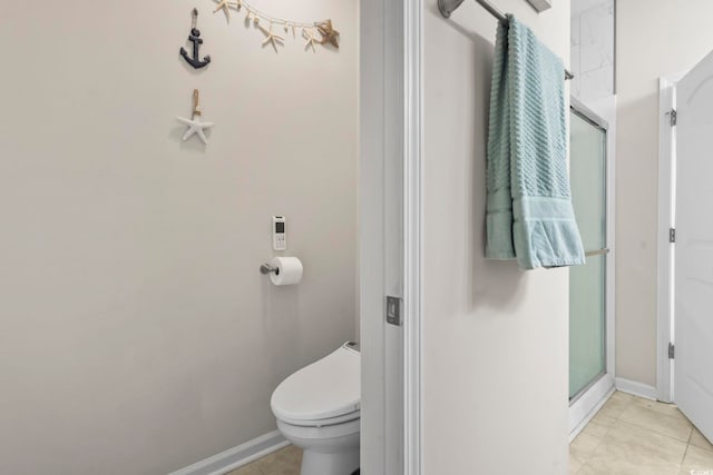 full bath featuring tile patterned floors, a stall shower, toilet, and baseboards