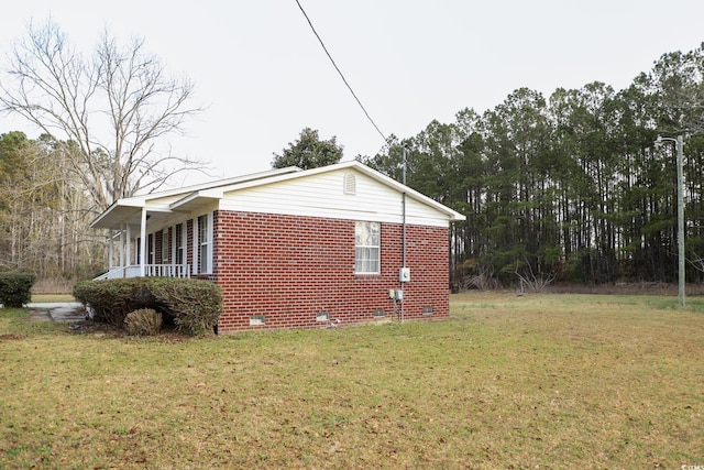 view of home's exterior with crawl space, a lawn, and a porch