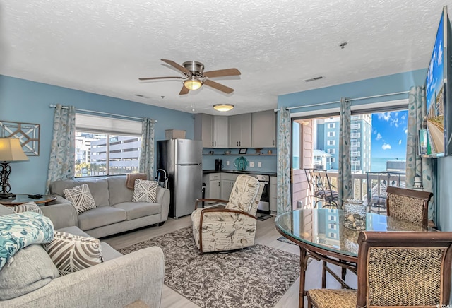 2710 S Ocean Blvd Unit 404, Myrtle Beach, SC 29577 - living area featuring ceiling fan, light wood finished floors, a textured ceiling, and visible vents