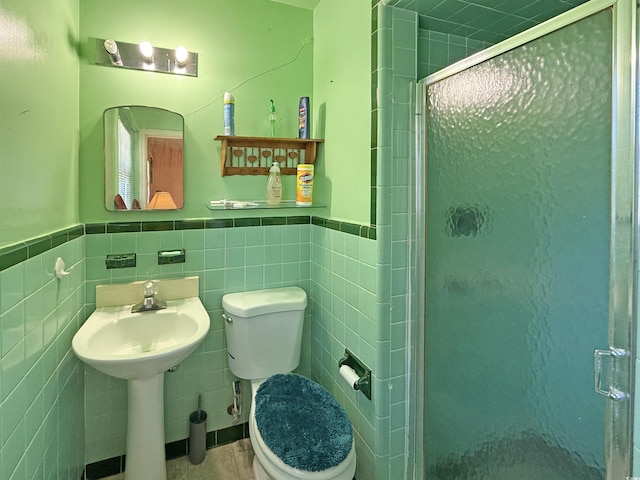 full bath with a shower stall, toilet, and wainscoting