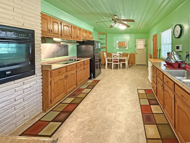 kitchen featuring a wall unit AC, ceiling fan, black appliances, light countertops, and under cabinet range hood