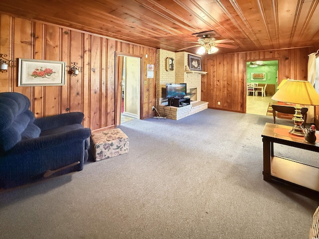 carpeted living room with wooden ceiling, a wood stove, a ceiling fan, and wood walls