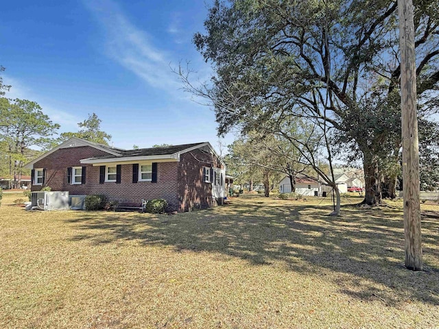 view of side of property featuring a lawn and brick siding