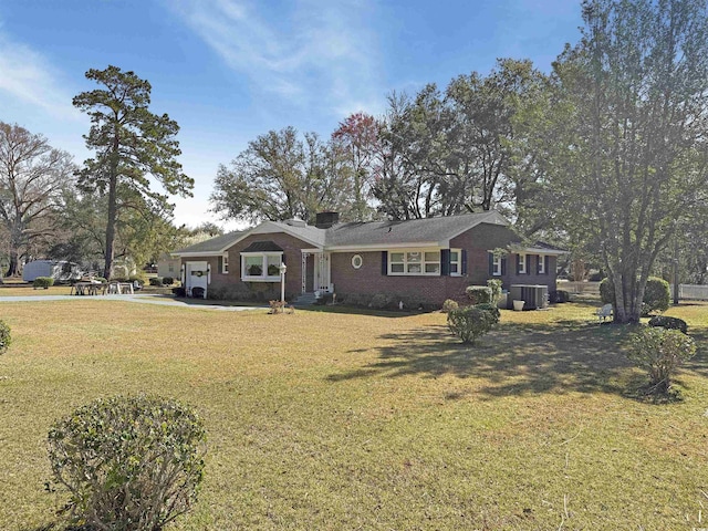 single story home with driveway, cooling unit, a front yard, an attached garage, and brick siding