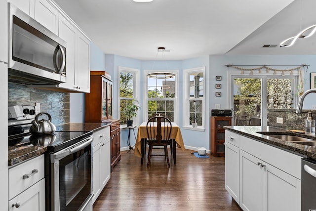 kitchen with visible vents, backsplash, stainless steel appliances, and a sink