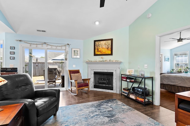 living room featuring vaulted ceiling, a ceiling fan, visible vents, and a wealth of natural light