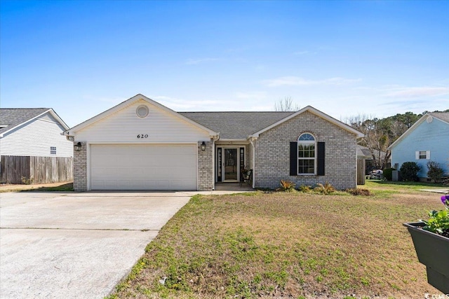 single story home featuring driveway, fence, a front yard, a garage, and brick siding