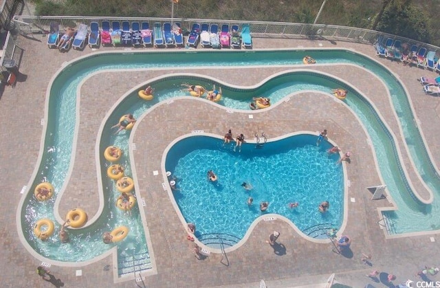 view of swimming pool with a water play area and a hot tub