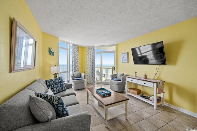 tiled living room with a wall of windows, baseboards, and a textured ceiling