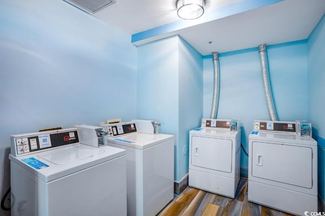 community laundry room with wood finished floors and washing machine and clothes dryer