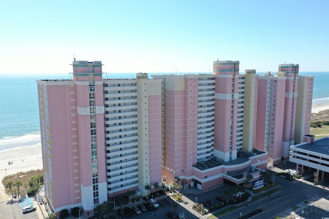 view of building exterior with a water view and a view of the beach