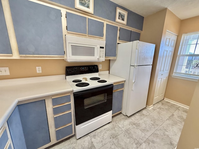 kitchen with baseboards, white appliances, and light countertops