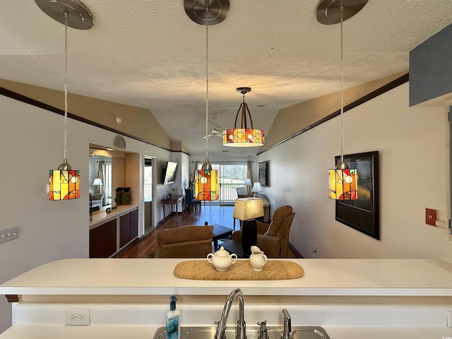 kitchen featuring hanging light fixtures, lofted ceiling, and a textured ceiling