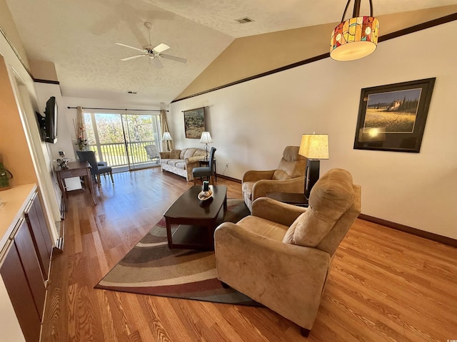 living room featuring wood finished floors, baseboards, visible vents, ceiling fan, and vaulted ceiling