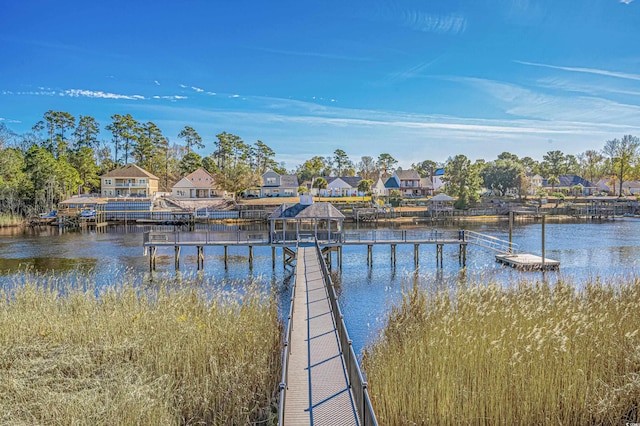 view of dock with a residential view and a water view